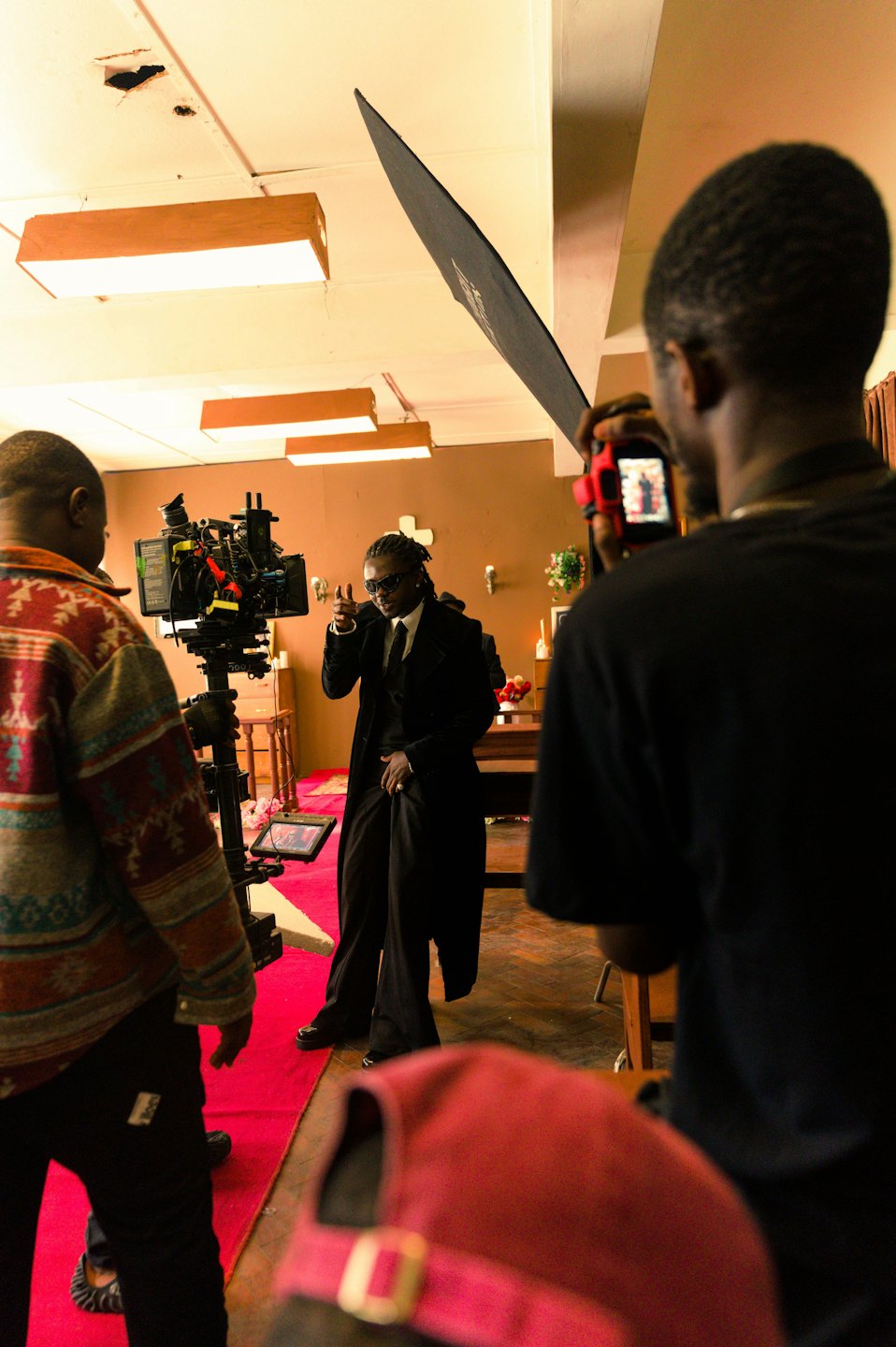 Man in a suit gives a thumbs-up to a film crew.